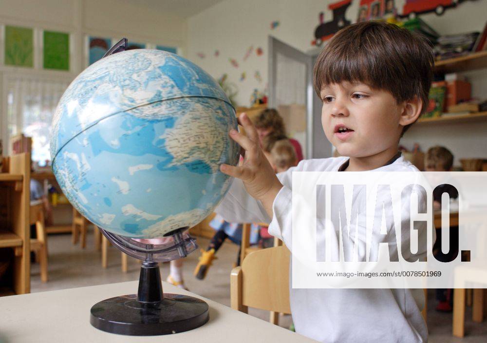 Ein Junge mit einer Weltkugel in einer Montessori Kita in Berlin