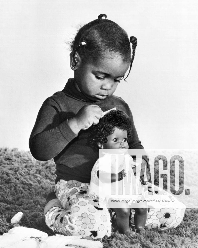 Los Angeles, California: 1974 A young girl brushing the hair of her new ...