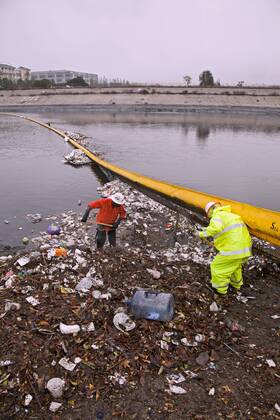 Trash Net In Channel Department of Public Works workers clean up garbage that accumulates in ...
