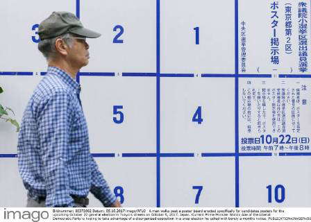 A man walks past a poster board erected specifically for election ads ...