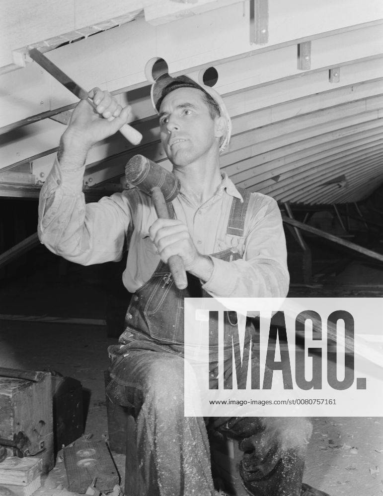 July 1942 Man working with a chisel on a beam of a motor torpedo boat ...