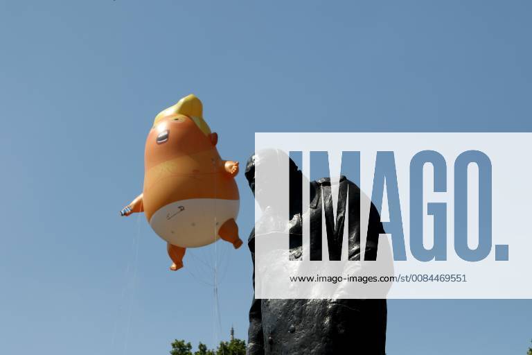 A Donald Trump baby blimp, behind the Winston Churchill statue, flies ...