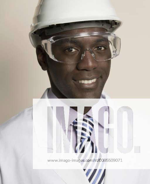 Laboratory worker wearing hard hat, protective goggles and lab coat Y