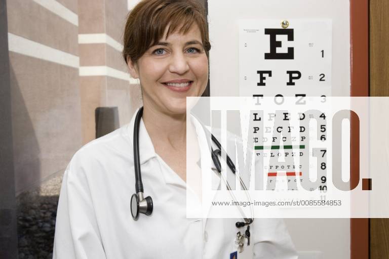 A doctor standing in front of an eye chart, smiling Albuquerque, New