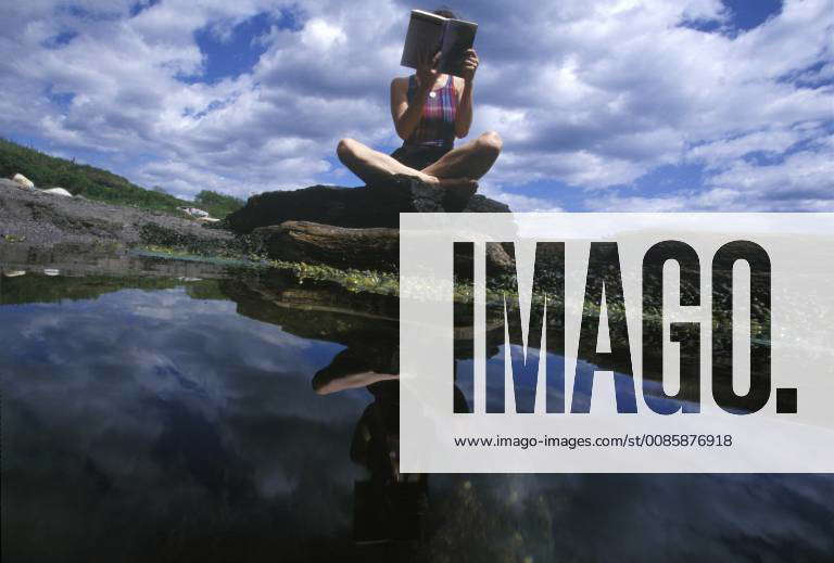 A woman reads a novel on the rocks at Kettle Cove in Cape Elizabeth ...