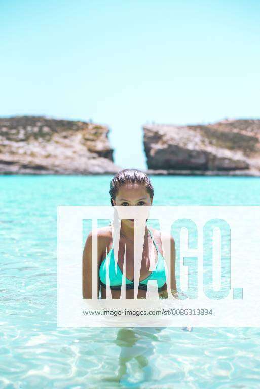 Mlata, Teenage girl wearing bikini, standing in the sea at Comino