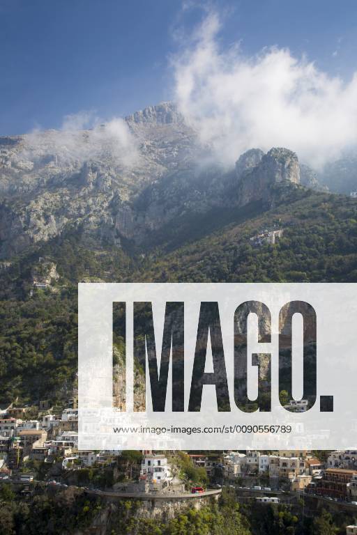 Massive mountains dwarf the town of Positano along the Amalfi Coast ...