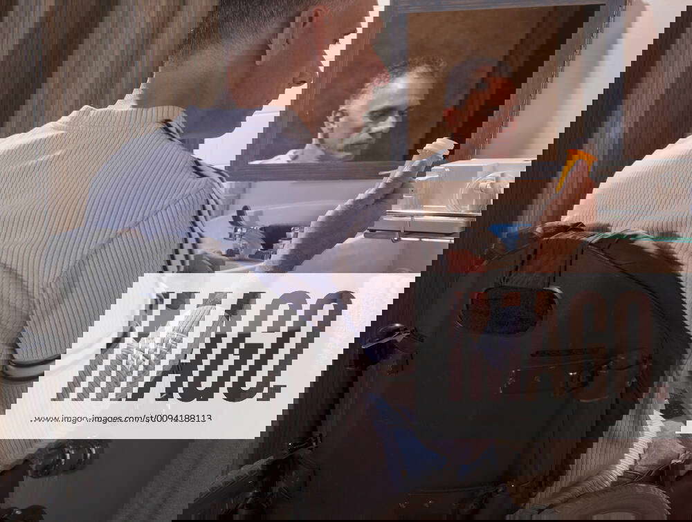 Man with spinal cord injury in a wheelchair looking at a pill bottle