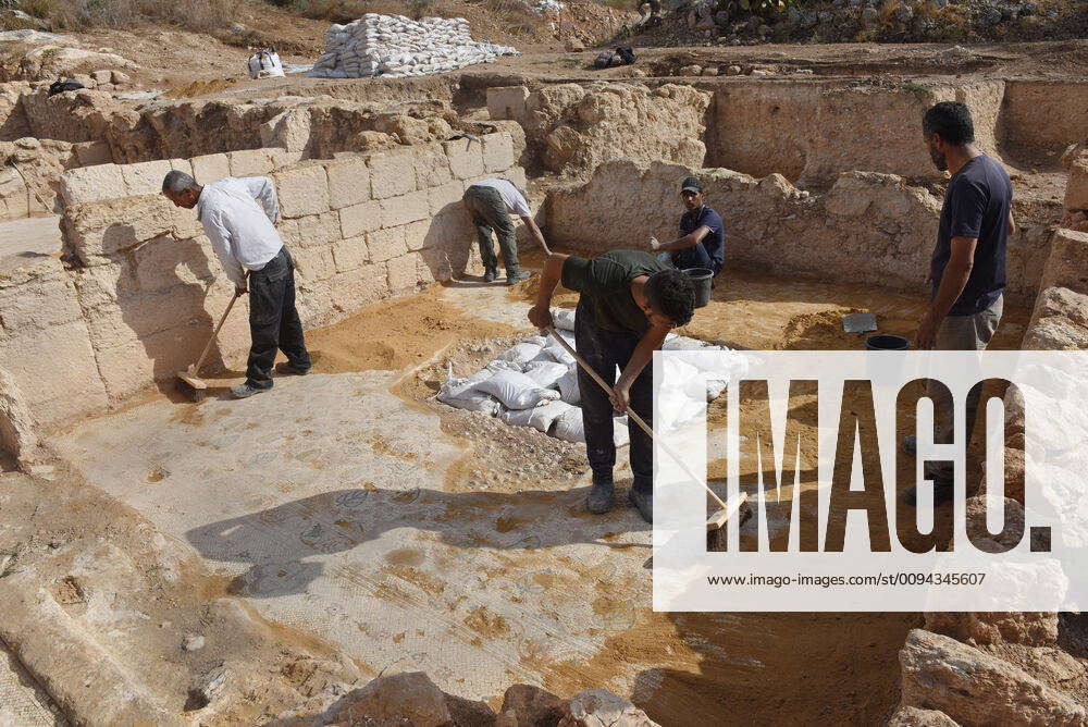 Workers of the Israel Antiquities Authority clean a mosaic floor in a ...