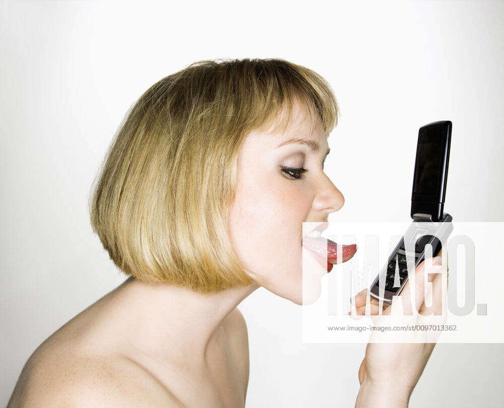 Woman licking phone. Side view of young blonde caucasian woman who is about  to lick her