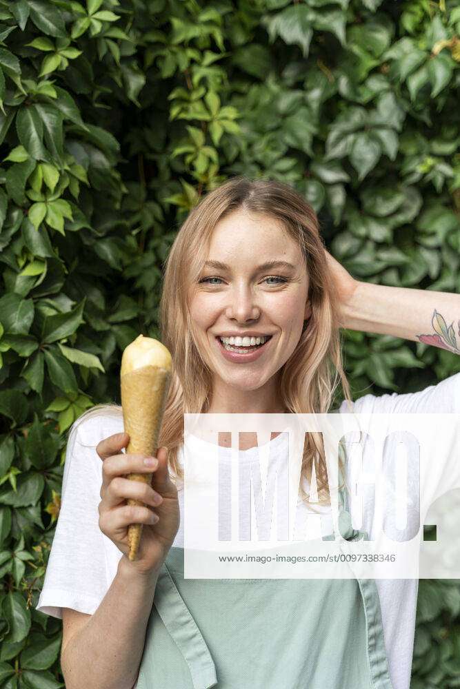 Portrait of happy young woman with ice cream cone model released ...