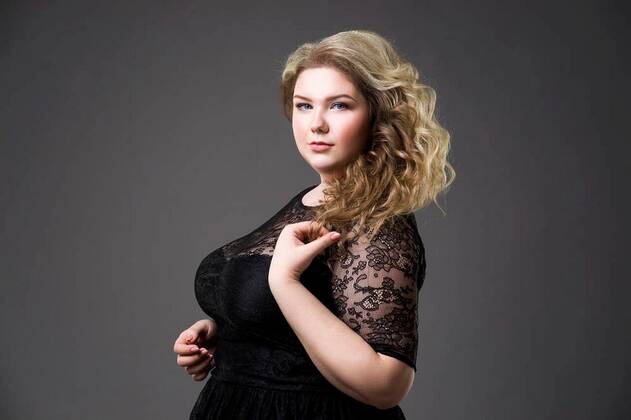 Portrait of young beautiful plus size model in black dress, xxl woman in  blurred studio background - Stock Image - Everypixel