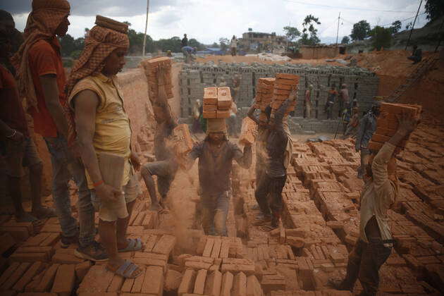 Bhaktapur, Nepal: Laborers balance bricks on their head at a brick kiln ...