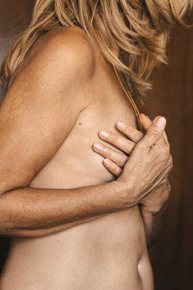 Close-up of a nude senior woman touching her breast model released  Symbolfoto property released