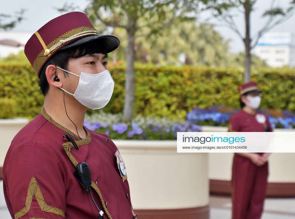 A staff member stands in front of the gate during the demonstration for reopen at the Universal