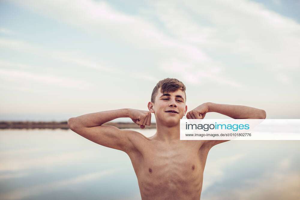 Teenage Boy Flexing Muscles Stock Photo - Download Image Now