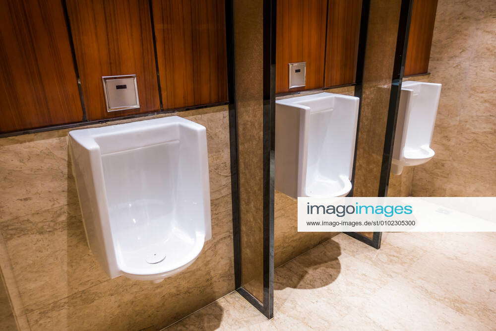 A row of automatic flushing urinals in the men s public toilet