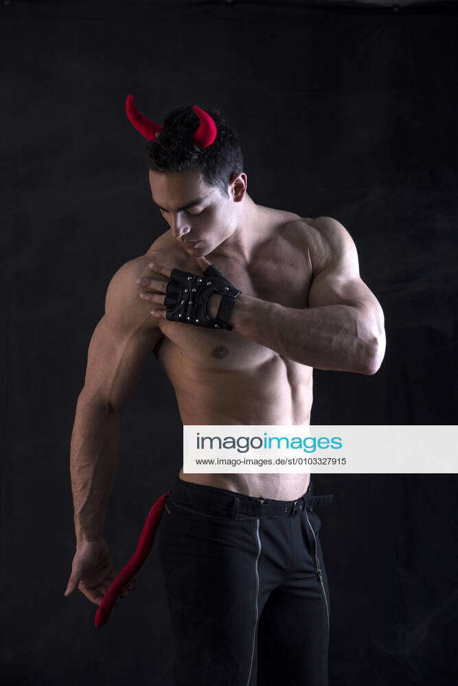 Shirtless muscular male bodybuilder dressed with devil costume