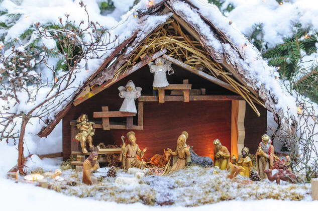 Christmas crib in the snow A small crib stands in a snowy garden romantically illuminated garden