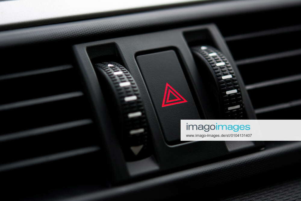Closeup of hazard alarm light switch on top of car control panel