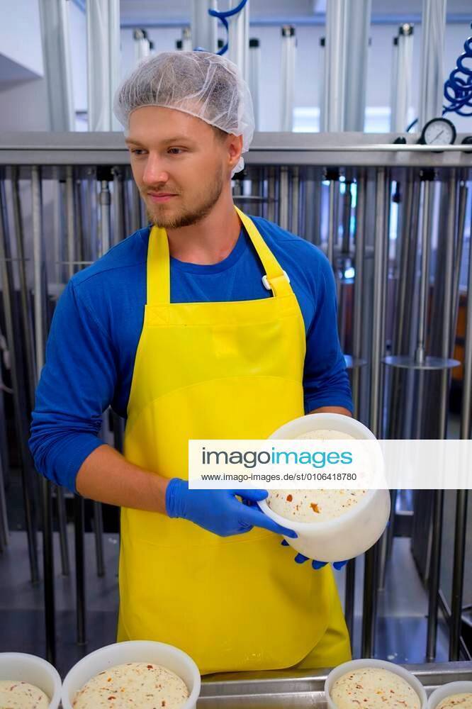 Handsome cheesemaker is making curd cheese in his