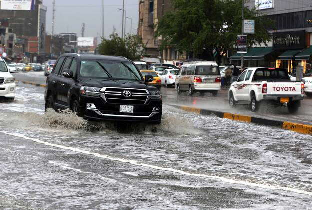 (201121) -- BAGHDAD, Nov. 21, 2020 () -- Vehicles run on flooded roads ...