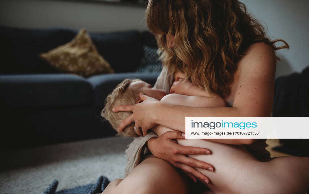 Baby breastfeeding naked with mom holding and hugging him Munich, BY
