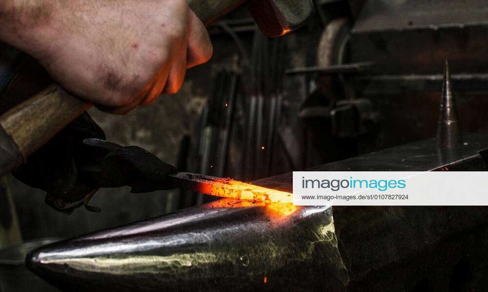 Blacksmith at work, hit with a hammer by a hot metal on the anvil