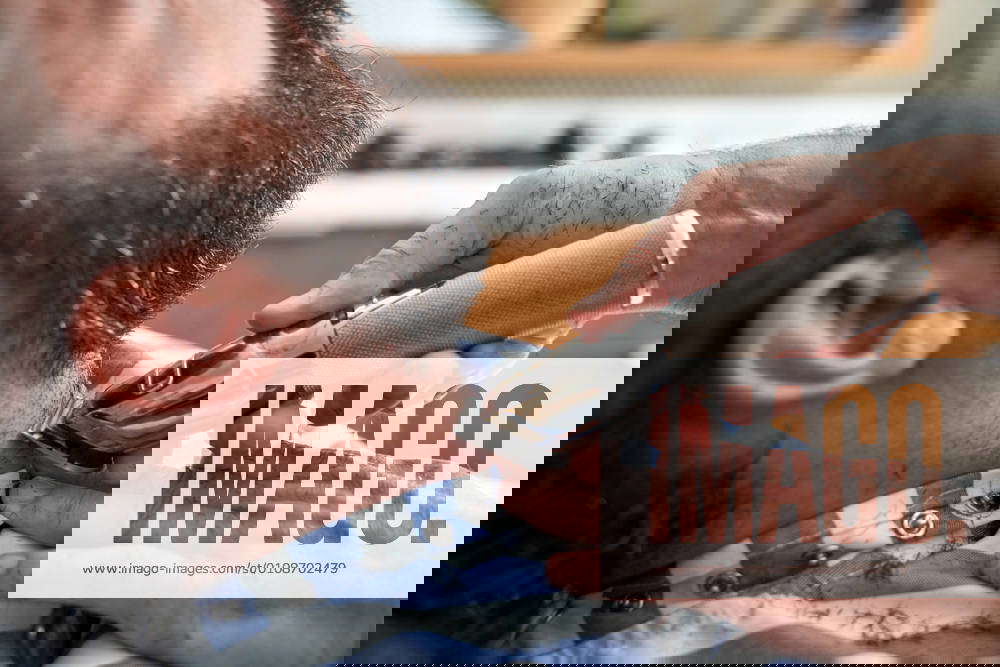 Professional barber using electric slicer during beard hairdressing
