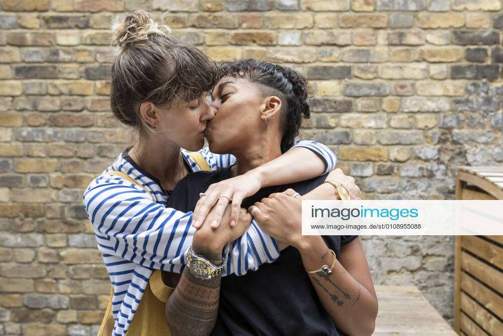 Lesbian couple kissing each other while standing at back yard