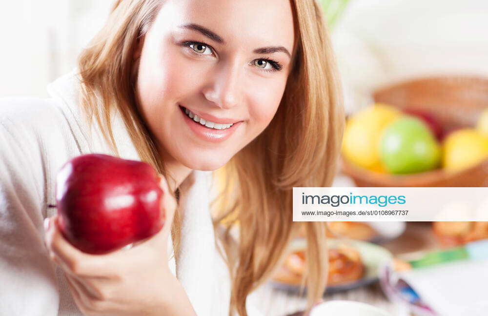 Happy woman eating apple Portrait of cute happy woman eating red ripe