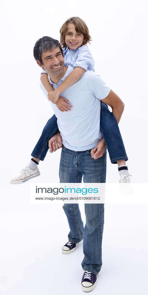 Man giving boy piggyback ride Man giving boy piggy back ride against white  background, model