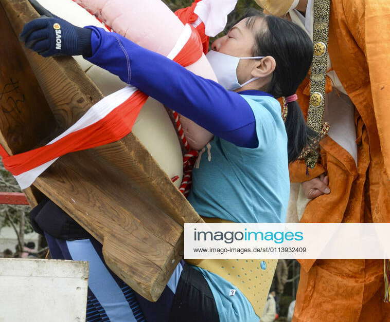 Rice cake lifting at Kyoto temple A woman tries to lift up giant rice