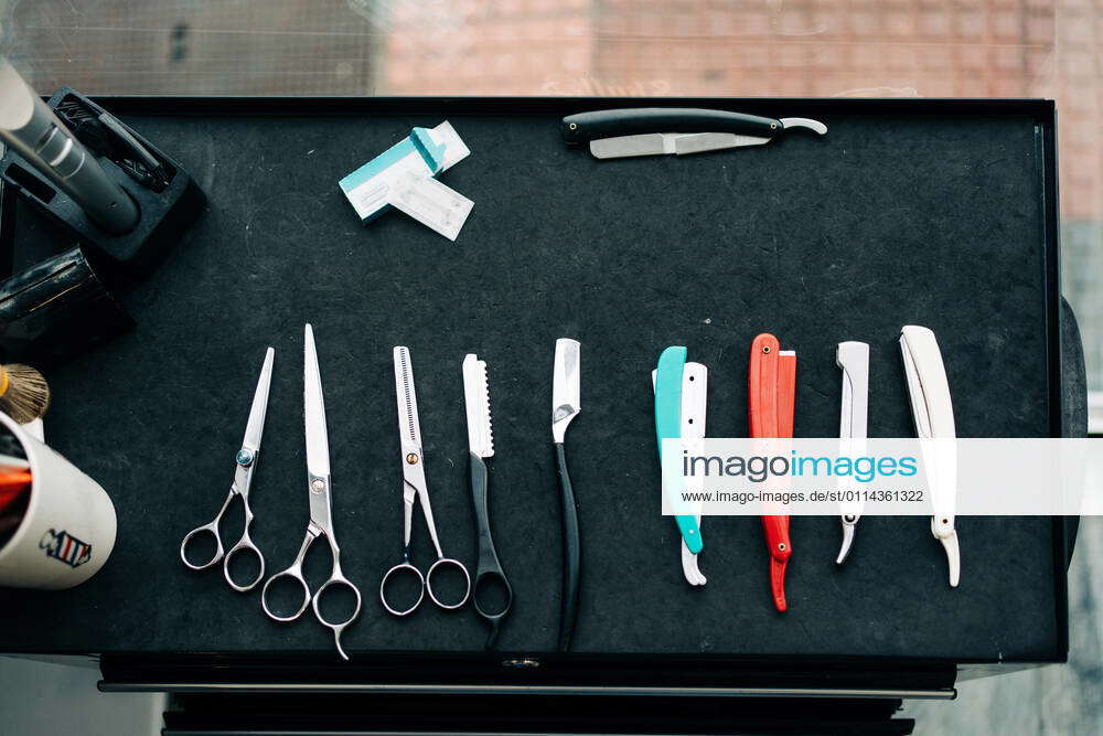 Top view of assorted scissors near straight razors with sharp metal