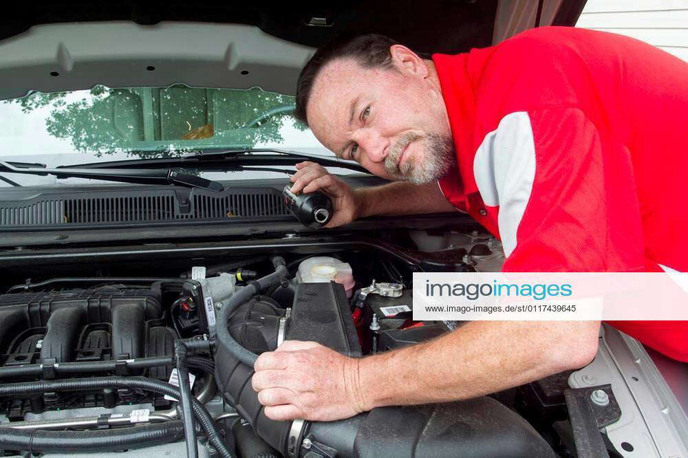 A mechanic putting brake fluid in a customer s car. xFotosearchxLBRFx