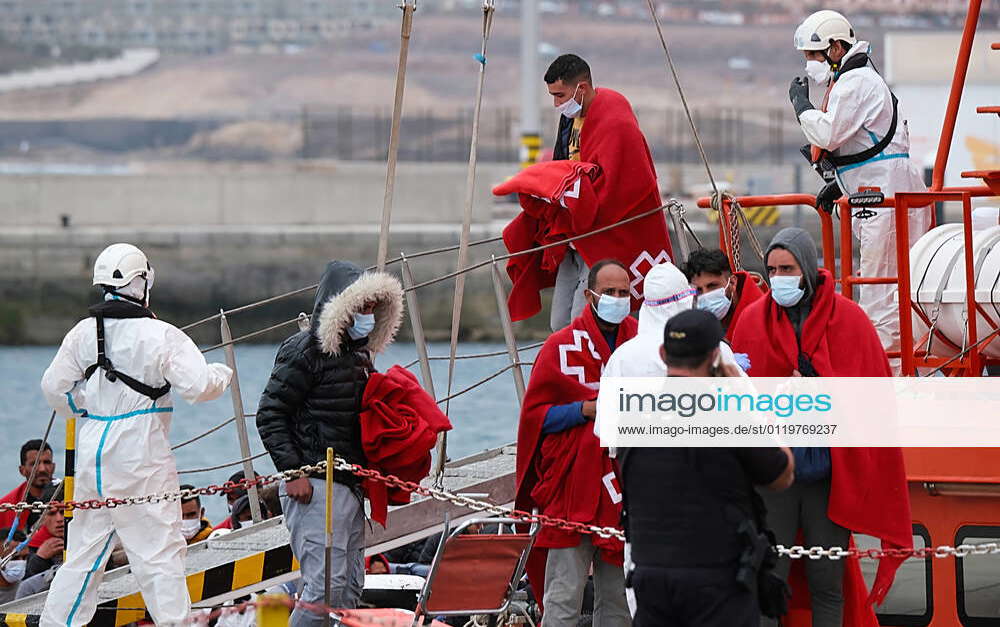 A group of migrants with Red Cross blankets on their arrival in Puerto ...