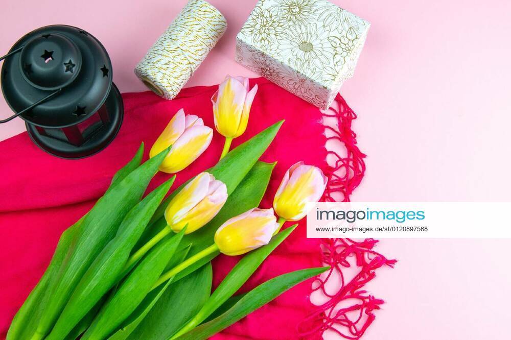 Preparing for the packaging of gifts, on the table laid out red and white wrapping paper, threads