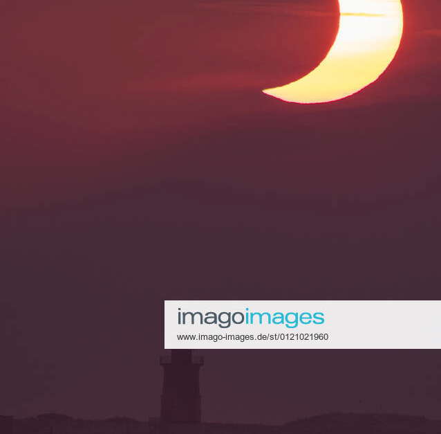 June 10, 2021, Lewes, Delaware, USA A partial solar eclipse is seen as the sun rises behind the