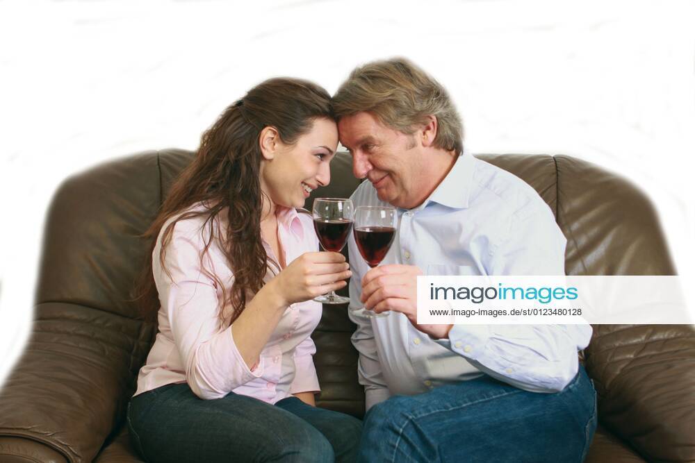 Sugardaddy drinking red wine with a young woman on a sofa sugar daddy ...