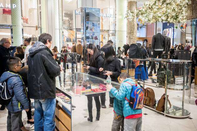 Shoppers browse Coach handbags in the Macy's Herald Square