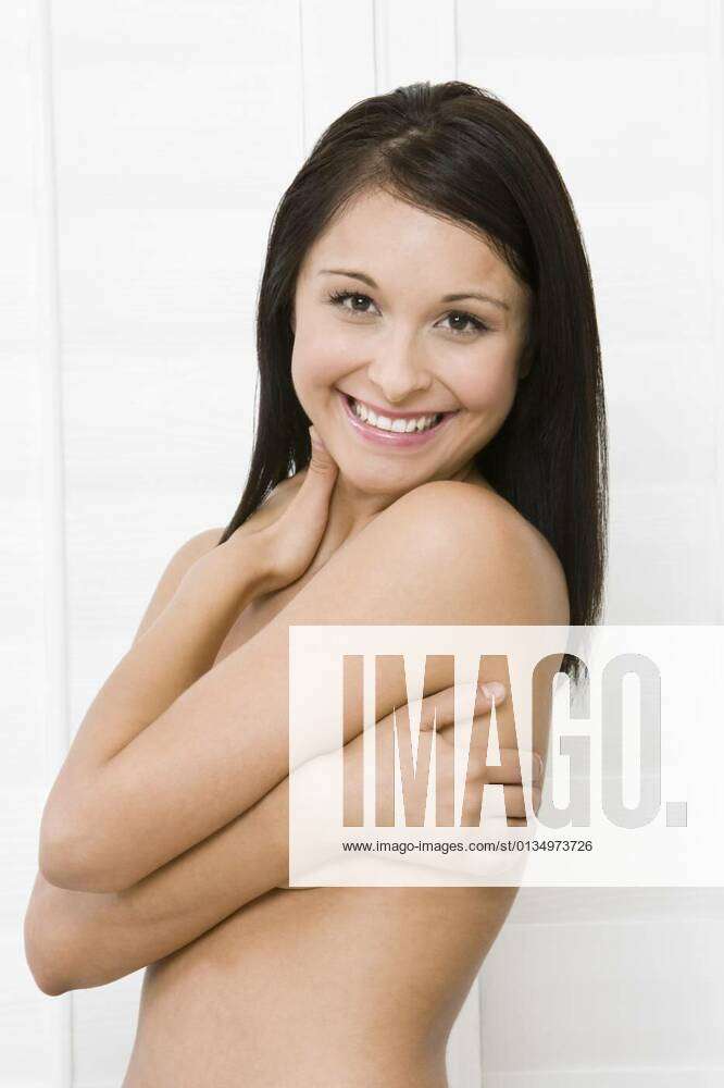 Smiling woman covering breast with hand