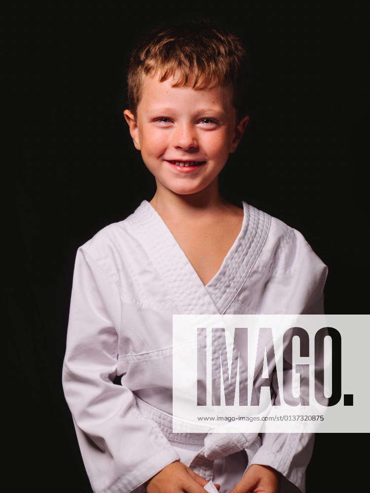 cute-boy-in-karate-kimono-laughing-happily-with-mouth-opened-in-studio