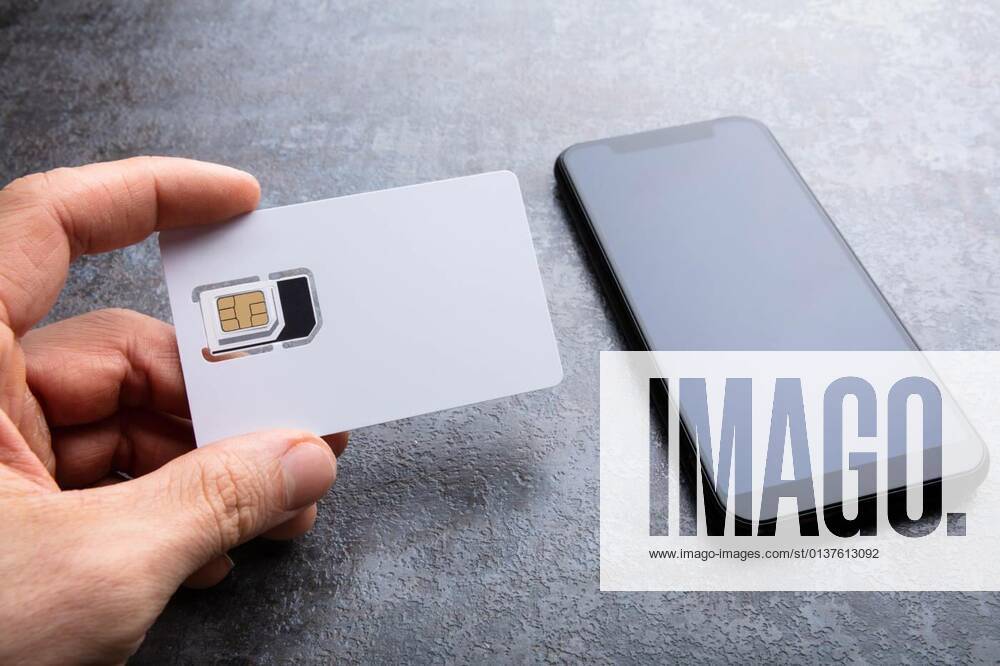 Human s Hand Holding Sim Card Near Smartphone