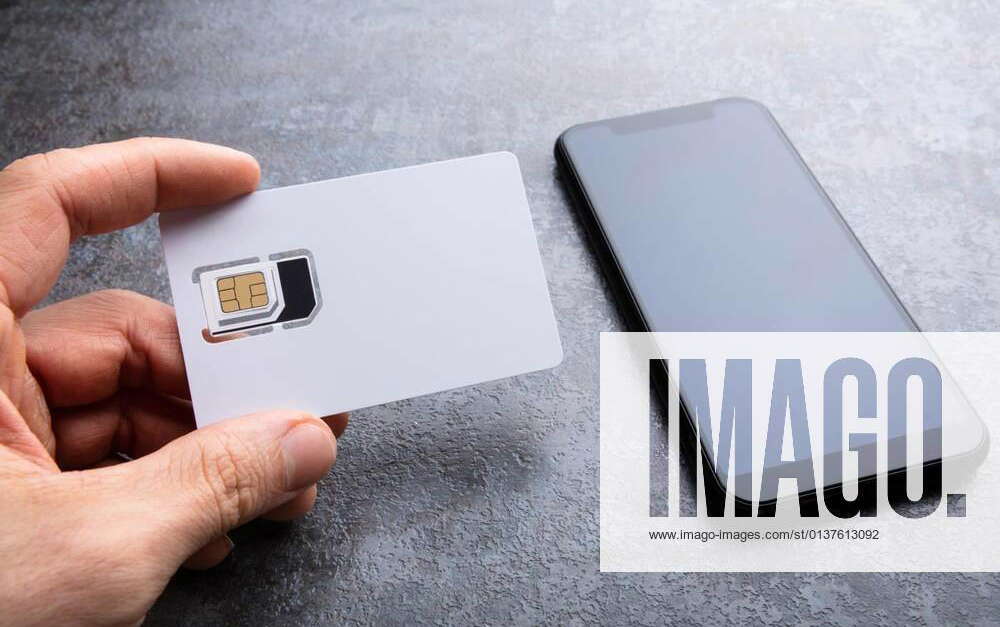 Human s Hand Holding Sim Card Near Smartphone