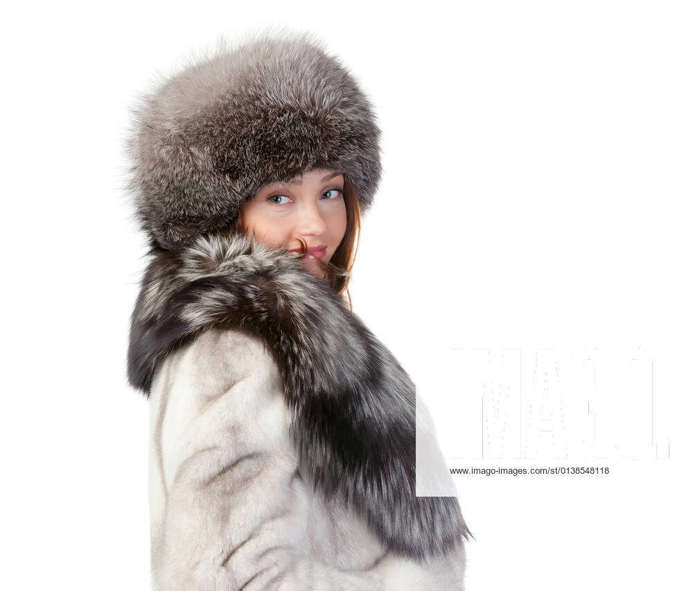 Sexy woman wearing a stylish winter fur coat and hat for protection against  the bitter cold