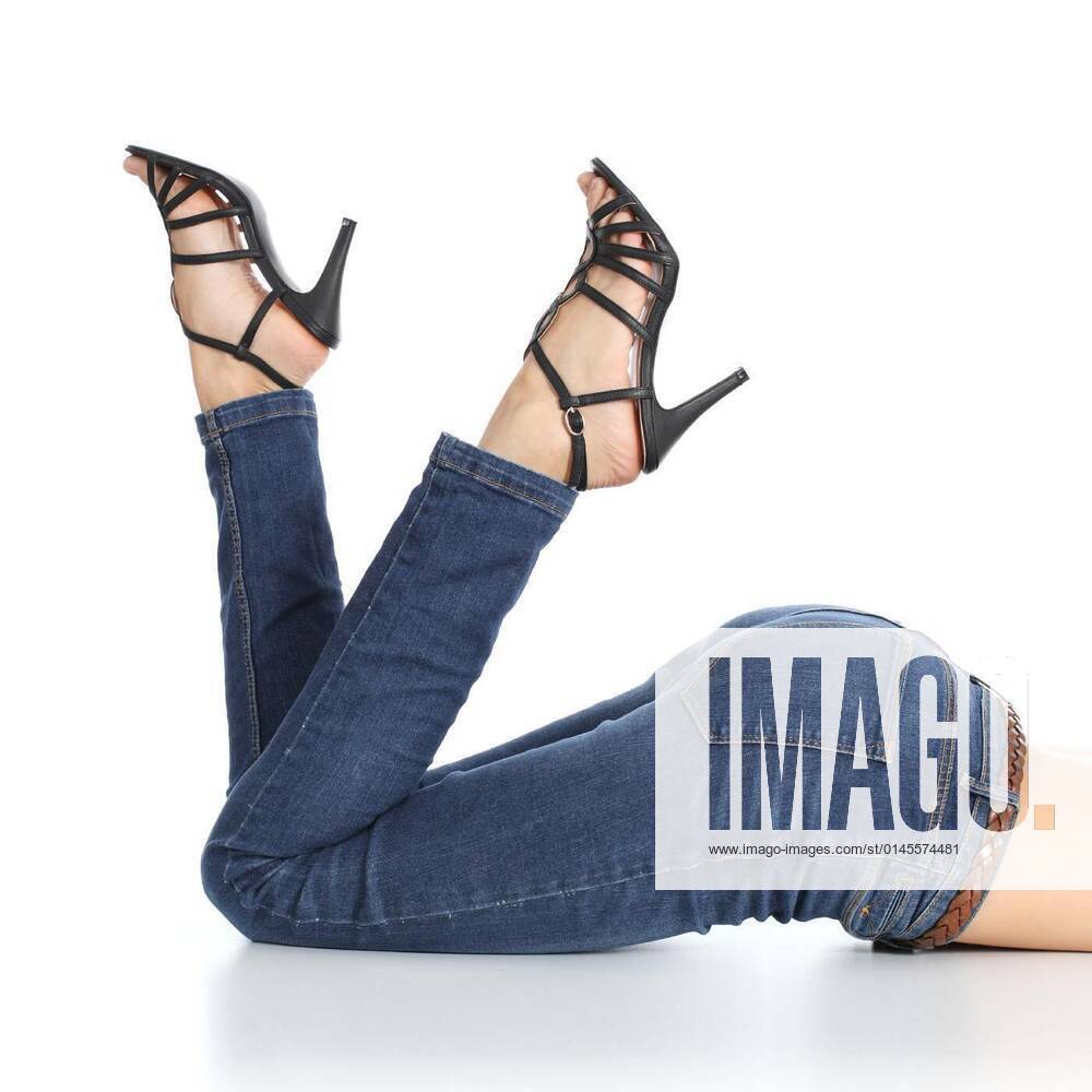 Woman legs lying with jeans and sandal heels pointing up model released,  Symbolfoto