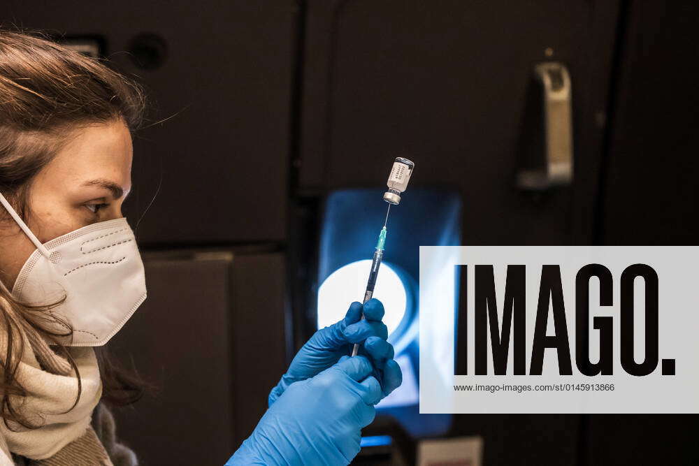 Syringe Helper A helper prepares a vaccination syringe She takes the vaccine from an ...