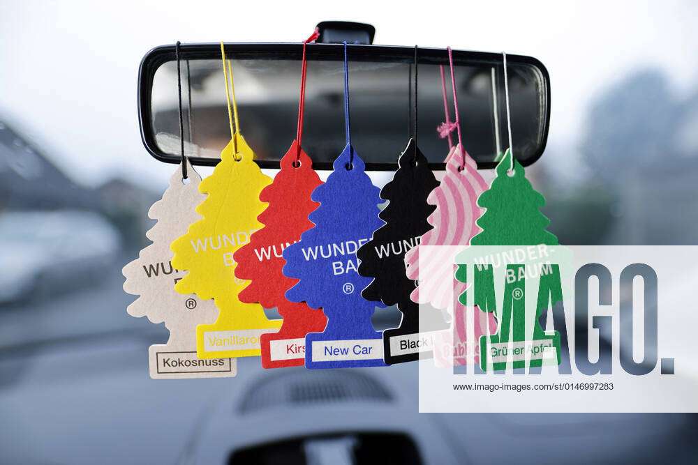 Several Wunder Baum Little Trees brand car fragrance and air fresheners  hang from a rearview