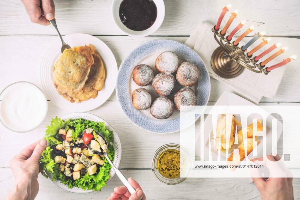 Traditional Hanukkah dishes on the white wooden table top view