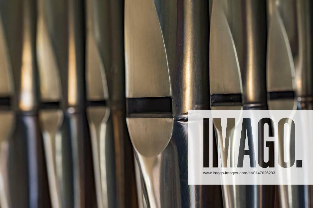 Closeup of organ pipes made of lead sheet metal standing in a row in a